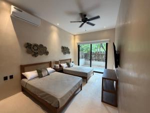 ein Schlafzimmer mit zwei Betten und einem Deckenventilator in der Unterkunft Calakmul Tulum in Cedro + 61 Fotos