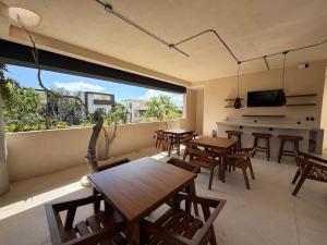 ein Raum mit Tischen und Stühlen und einem großen Fenster in der Unterkunft Calakmul Tulum in Cedro