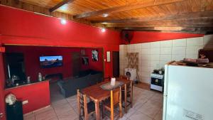 een keuken met een tafel en een rode muur bij el rincon de roma in Puerto Iguazú