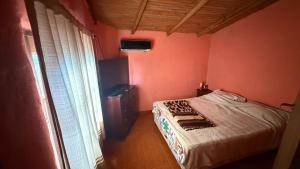 een kleine slaapkamer met een bed en een raam bij el rincon de roma in Puerto Iguazú