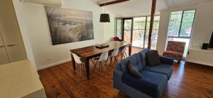 a living room with a table and a blue couch at Beachcomber - 39 Phillip Drive South West Rocks in South West Rocks