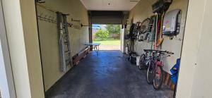 a hallway of a garage with a table and two bikes at Beachcomber - 39 Phillip Drive South West Rocks in South West Rocks