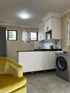 una cucina con bancone e lavatrice di Crème de la crème Tiny Cottage a Durban Altre 8 foto