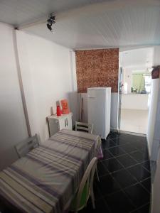 a small room with a bed and a refrigerator at Brisa Tropical in Ilhéus