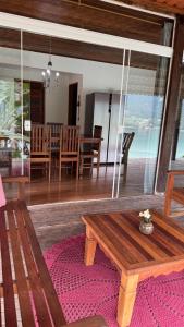 ein Wohnzimmer mit einem Holztisch und einem Esszimmer in der Unterkunft Casa da Praia in Paraty