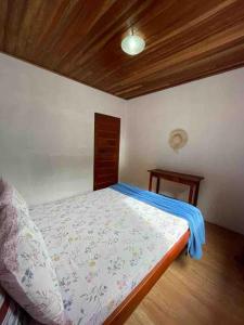 een slaapkamer met een bed en een houten plafond bij Casa da Praia in Paraty