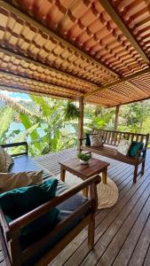 eine Holzterrasse mit Bänken und einer hölzernen Pergola in der Unterkunft Casa da Praia in Paraty