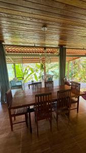 een eetkamer met een houten tafel en stoelen bij Casa da Praia in Paraty