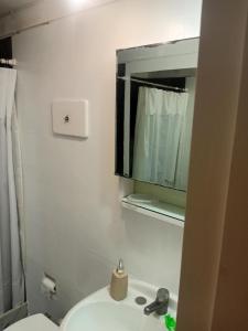 een badkamer met een toilet, een wastafel en een spiegel bij peninsula fontemar in Punta del Este +28 foto's