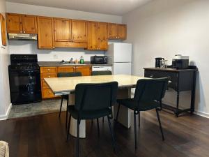 a kitchen with wooden cabinets and a table and chairs at New Management - Collingwood Getaway in Collingwood +9 photos