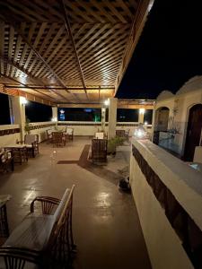 an empty patio with tables and chairs at night at Nubian Soul Guest Houses in Aswan