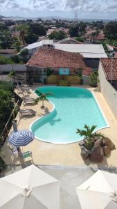 an overhead view of a swimming pool with chairs and umbrellas at Caminho do mirante, suíte 5 in Iguaba Grande