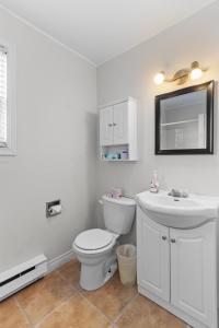 a white bathroom with a toilet and a sink at Modern 2BR Suite Parking Laundry in Torbay
