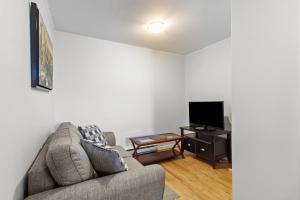 a living room with a couch and a tv at Modern 2BR Suite Parking Laundry in Torbay