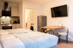 - 2 lits dans une chambre avec une table et une cuisine dans l'établissement Luxury Homburg, à Hombourg