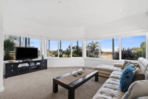un soggiorno con divano e TV a schermo piatto di Seaview Apollo Escape - BYO Linen a Apollo Bay