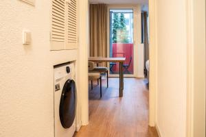 une chambre avec un lave-linge et une table dans l'établissement Luxury Homburg, à Hombourg