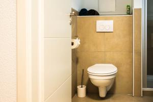 une salle de bain avec des toilettes blanches dans une chambre dans l'établissement Luxury Homburg, à Hombourg