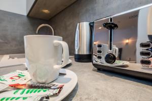 een kopje koffie op een bord naast een magnetron bij Essential Studio in the Heart of Huddersfield in Huddersfield