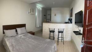a bedroom with a bed and two bar stools at Caminho do mirante, suíte 5 in Iguaba Grande