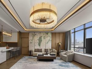 een woonkamer met een bank en een kroonluchter bij Swissotel Beijing Hong Kong Macau Center in Beijing