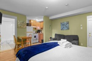 a bedroom with a large bed and a kitchen at Cozy Manor Studio Parking WiFi in St. John's
