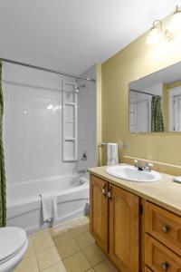 een badkamer met een wastafel, een bad en een toilet bij Cozy Manor Studio Parking WiFi in St. John's