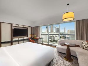 ein Hotelzimmer mit einem Bett und einem großen Fenster in der Unterkunft Fairmont Singapore in Singapur + 170 Fotos