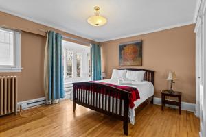 een slaapkamer met een bed en een raam bij Midstream Premier 2BR Wi-Fi Parking in St. John's