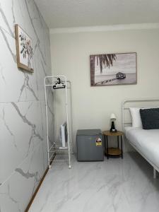 ein weißes Zimmer mit einem Bett und einer weißen Marmorwand in der Unterkunft Convenient Single Stay in Vibrant Cabramatta - Shared Bathroom in Cabramatta