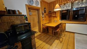 eine Küche mit Holzboden und einem Holztisch in der Unterkunft Stara chałupa in Murzasichle + 45 Fotos