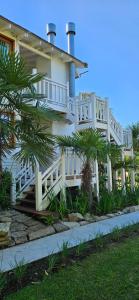 a white house with palm trees in front of it at Complejo Pelicano Chapadmalal in Chapadmalal