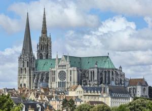 eine große Kathedrale mit grünem Dach und Türmchen in der Unterkunft Studio cœur de Chartres, à côté de la cathédrale in Chartres