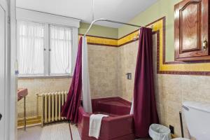 een badkamer met een douche en een rood bad bij Midstream Manor 1BR Parking WiFi in St. John's