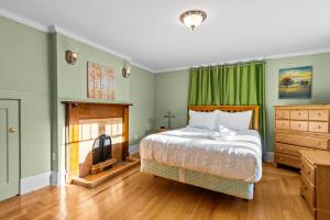 een slaapkamer met groene muren, een bed en een open haard bij Midstream Manor 1BR Parking WiFi in St. John's