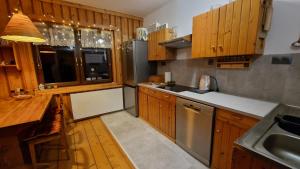 eine Küche mit Holzschränken und Geräten aus Edelstahl in der Unterkunft Stara chałupa in Murzasichle