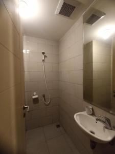 a bathroom with a sink and a shower with a mirror at Gatotkaca Hotels in Surabaya