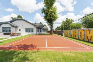 a tennis court in front of a house at 5 Beds Downtown OKC - Pickleball, Hot Tub, Firepit, GameRoom in Oklahoma City