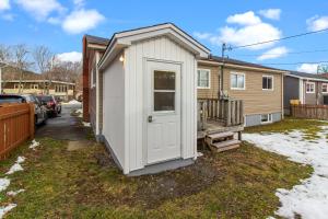 einen kleinen weißen Schuppen mit einer Tür im Hof in der Unterkunft Stylish 2BR WiFi Parking MUN Walk in St. John's