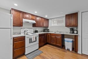eine Küche mit Holzschränken und weißen Geräten in der Unterkunft Stylish 2BR WiFi Parking MUN Walk in St. John's
