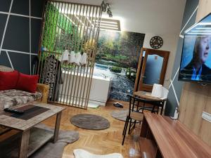 a living room with a couch and a tv at JACUZZI for RELAX - HOLLYWOOD Apartment, STUP, Sarajevo near Airport in Sarajevo
