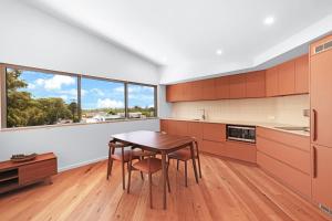 a kitchen with a table and chairs and a window at Ti Willa by Book Jervis Bay - Elevated Escape in Huskisson in Huskisson