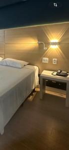 a bedroom with a bed and a table with a lamp at Flat em Santos próximo a praia e Vila Belmiro in Santos +22 photos