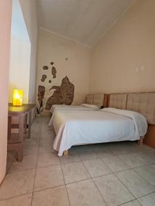 een slaapkamer met twee bedden en een tafel met een lamp bij Hostalgia in Puebla