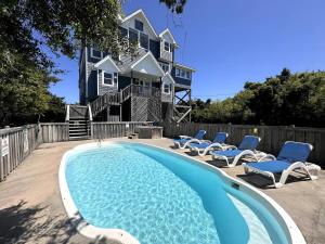 a house with a swimming pool and lounge chairs at How You Dune - Dog-Friendly Semi-Oceanfront in Avon
