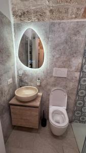 a bathroom with a sink and a toilet and a mirror at Casa Filomena in Polignano a Mare