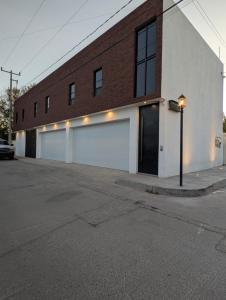 a large brick building with a white garage at Lina Élite Suites in Chihuahua