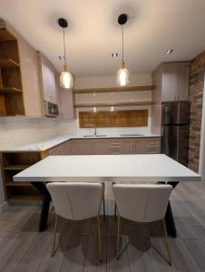 a kitchen with a white table and two white chairs at Lina Élite Suites in Chihuahua +6 photos