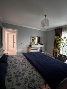 een slaapkamer met een groot bed met een blauwe deken bij Valmaris in Râmnicu Vâlcea