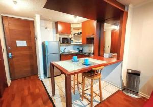 een keuken met een tafel en een koelkast bij Apart Merced Home in Santiago